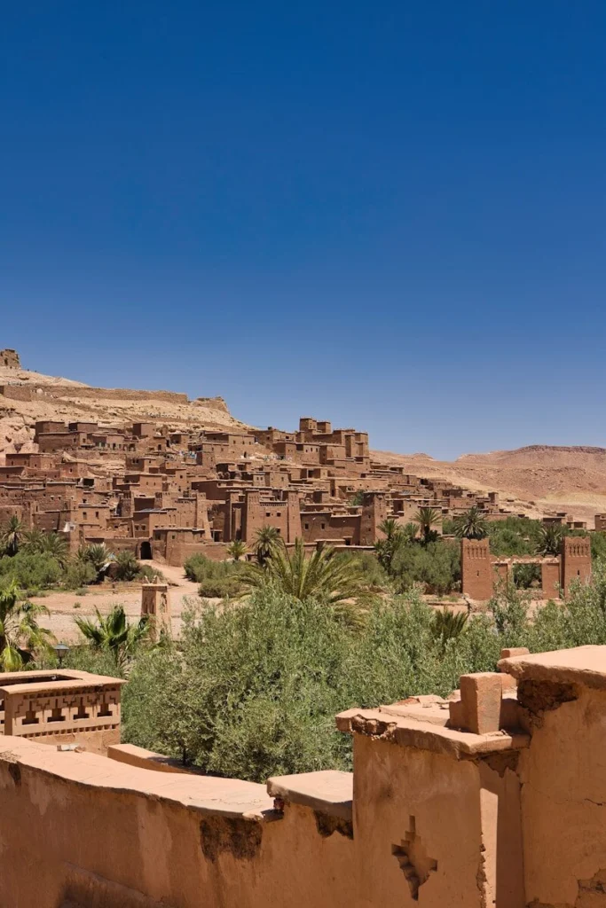 A village in the desert with a mountain in the background
